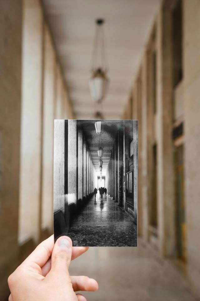 Exploring perspective using a black and white photo held in a modern corridor.