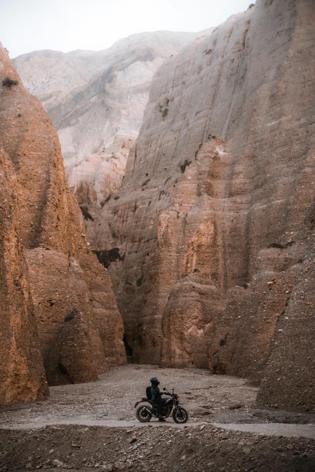 Adventurous motorcyclist navigating rugged cliffs in Gandaki Province, Nepal.