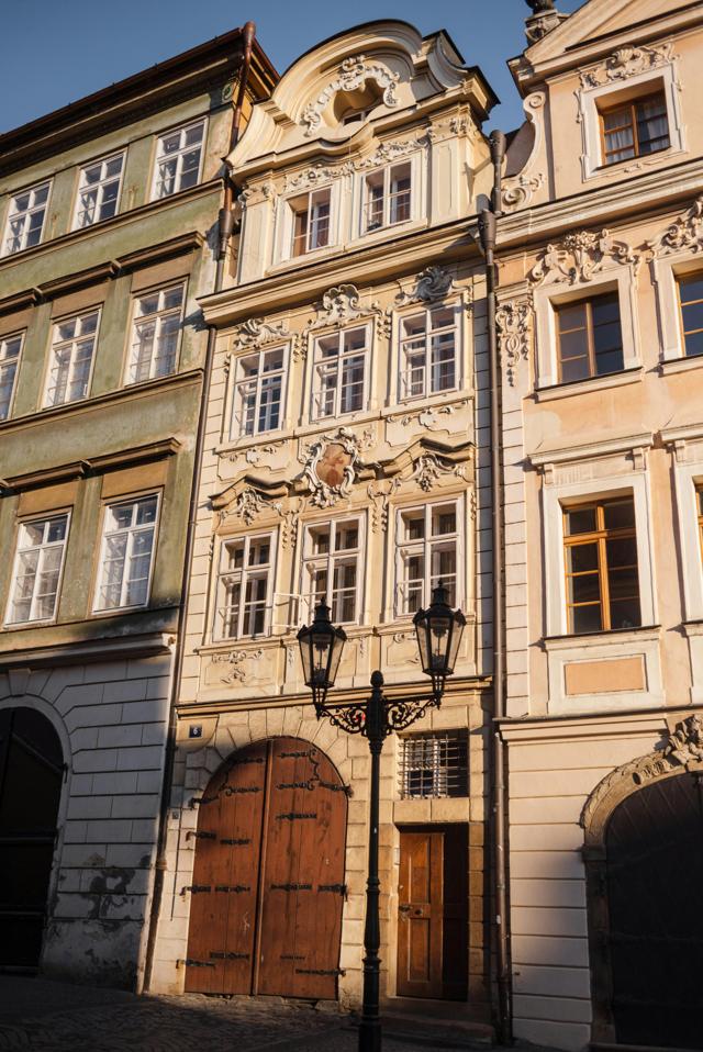 Intricate baroque architecture of Prague buildings, showcasing stunning facades in warm sunlight.